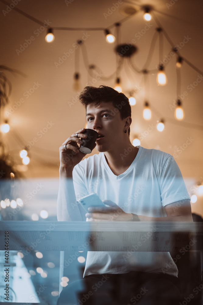 Young, handsome man is drinking his morning coffee in a cafe. Young, handsome man is drinking his morning coffee in a cafe.