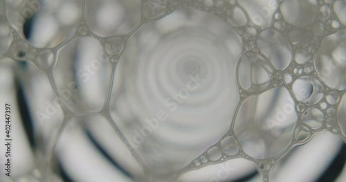 Static macro shot of soap cells over screen showing an animation. Animation gets reflected in the cells. photo