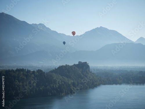 Panoramic view of hot air balloons over Lake Bled medieval castle Blejsko jezero Julian alps mountains Slovenia Europe