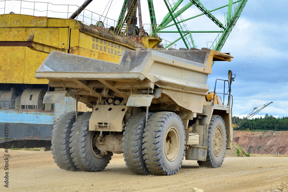 Mining truck and excavators working in the limestone open-pit. Loading and transportation of minerals in the dolomite mining quarry Mining truck and excavators working in the limestone open-pit. Loading and transportation of minerals in the dolomite mining quarry