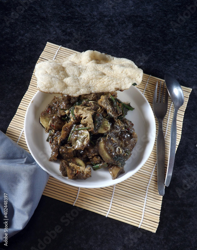 Rujak cingur or rujak petis is typical Indonesian salads which blends fruit, boiled vegetables, and cow nose with spicy peanut sauce which using fermented shrimp black paste as special ingredient. photo