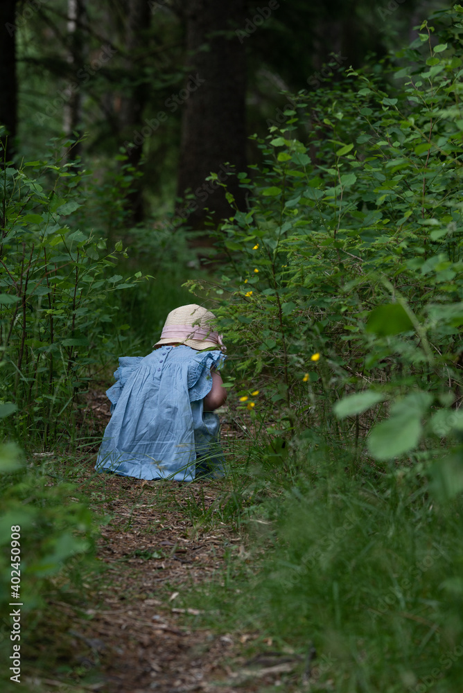 Young girl sitting on a path in a blue dress Young girl sitting on a path in a blue dress