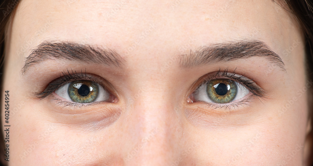 Close up of beautiful green eye of young woman without wrinkles or puffy eyes Close up of beautiful green eye of young woman without wrinkles or puffy eyes