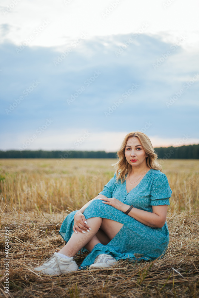 Beautiful single woman. a girl in a summer blue dress. Beautiful girl in the field. Bare female leg.Loneliness. Unity with nature. Beautiful single woman. a girl in a summer blue dress. Beautiful girl in the field. Bare female leg.Loneliness. Unity with nature.