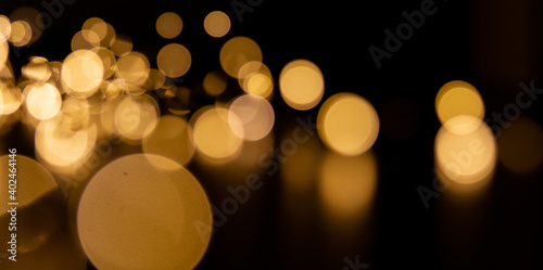 Golden bokeh lights banner background, abstract illumination texture in the dark photo