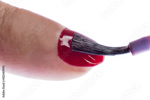 Red nail polish put on a nail.