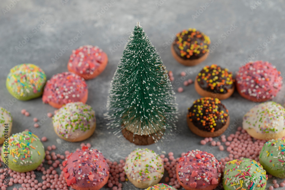 Colorful sweet small doughnuts with sprinkles and a cup of tea