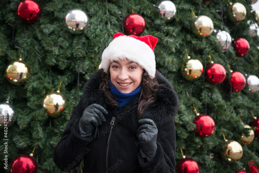 Portrait of a beautiful girl in a santa claus hat on a city Portrait of a beautiful girl in a santa claus hat on a city