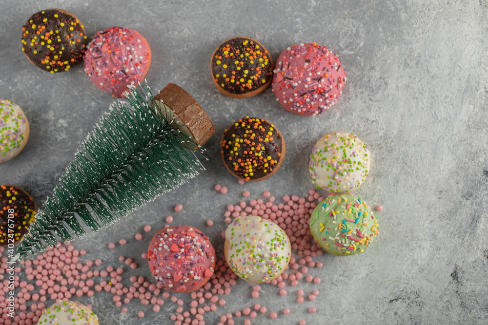 Colorful sweet small doughnuts with sprinkles and a cup of tea