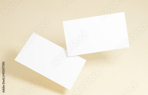 Floating Business Card Mockup. Closeup on two empty business cards floating in the air in front of the cardboard background.