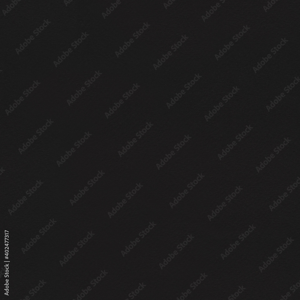 Seamless Black cardboard background with closeup on a piece of black colored paper.