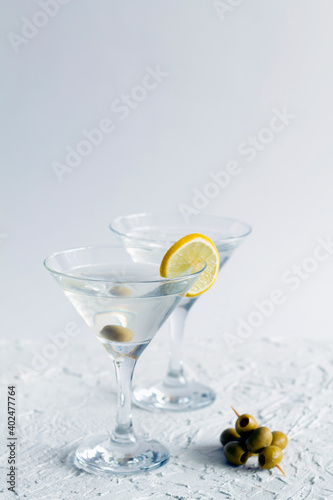 alcohol drinks. margarita cocktail in the bar. two martini glasses of cocktail and olives on white background. Glasses for martini with olives on the table. copy space. vertical