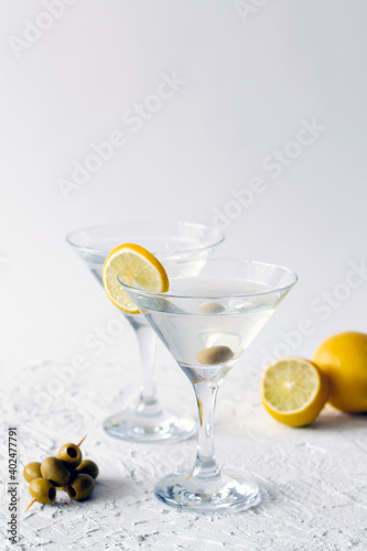 margarita cocktail in the bar. two martini glasses of cocktail with green mint and olives on white background. alcohol drinks. Glasses for martini with olives on the table. copy space. vertical