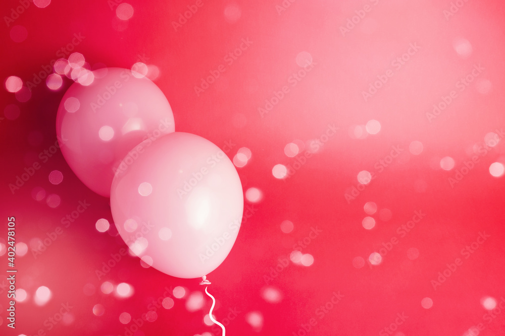 Bokeh blur of glitter over pink balloons with red background for Valentine's Day card.