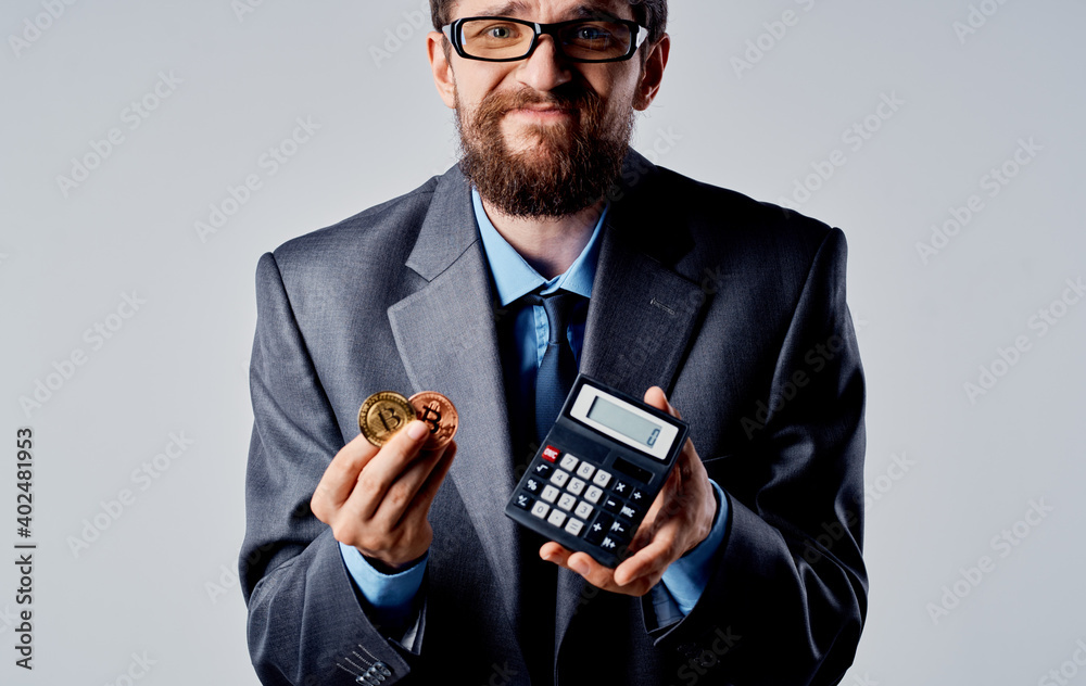 Businessman with calculator in hands and cryptocurrency Bitcoin wealth exchange rate Businessman with calculator in hands and cryptocurrency Bitcoin wealth exchange rate