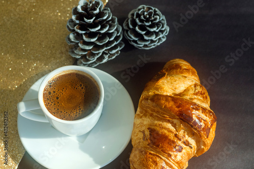 Cup of coffee on golden sparkling background, new year first  morning coffee concept, day after new year's day photo