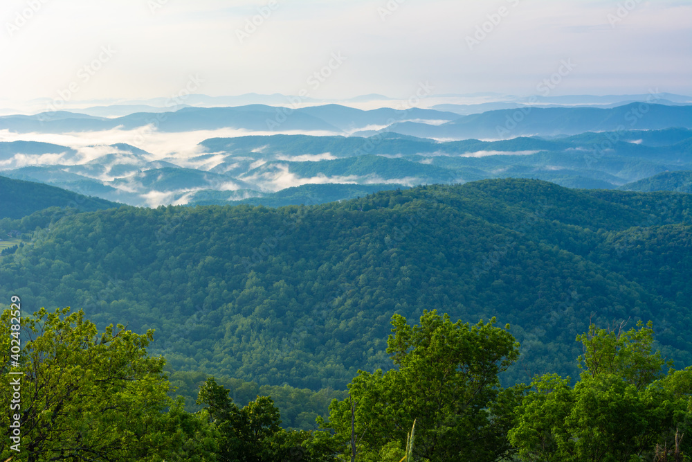 Morning Fog over the Blue Ridge mountains, summer morning and fog is weaving around the mountain peaks, looks as though the pecks are almost floating on water, photographed from the Blue Ridge Parkway Morning Fog over the Blue Ridge mountains, summer morning and fog is weaving around the mountain peaks, looks as though the pecks are almost floating on water, photographed from the Blue Ridge Parkway