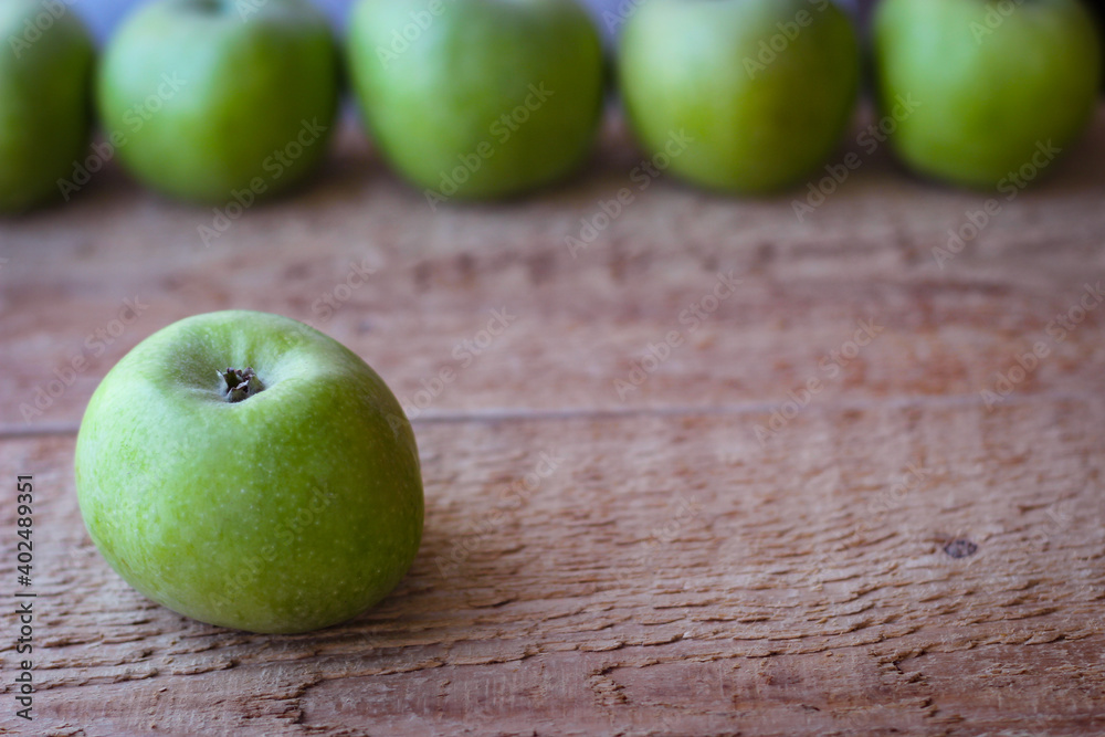 Green apples stand on a wooden surface Green apples stand on a wooden surface