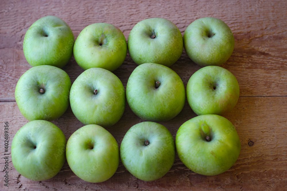 Green apples stand on a wooden surface Green apples stand on a wooden surface