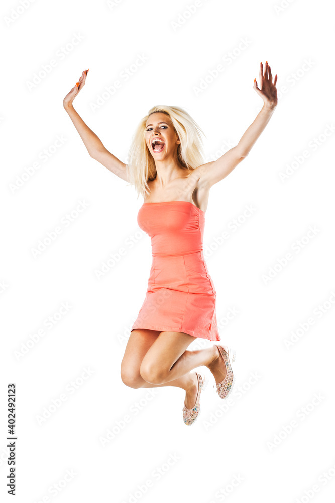 happy blond girl wearing pink dress jumping in the air against white background.
