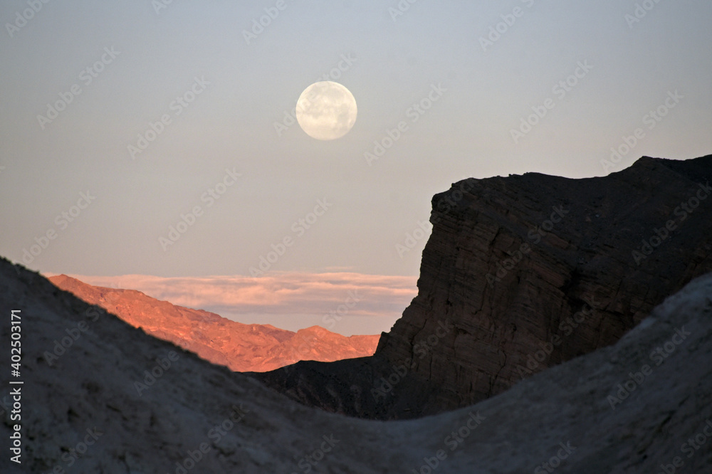 Moon setting at sunrise at Zabriskie Point, Death Valley, California, USA