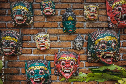 Balinese hindu masks on brick wall