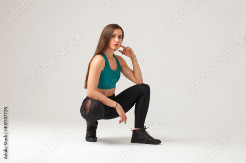 sporty hispanic sportswoman sitting crouch isolated on white background
