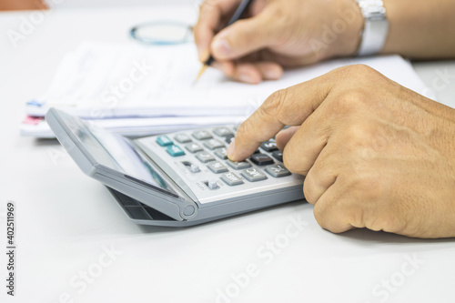 hand of man use a calculator to calculate income and expenses in the office concepts