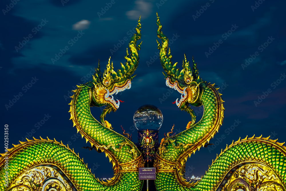 Fototapeta premium Background of Thailand's Chonburi religious attractions (Wat Khao Phra Khru viewpoint), with beautiful Buddha and Phaya Naga statues, tourists always come to make merit and take pictures at night.
