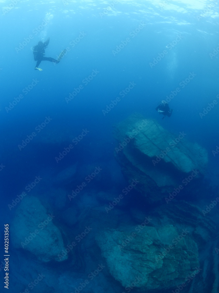 scuba diver underwater with rocks discovering reefs ocean scenery human