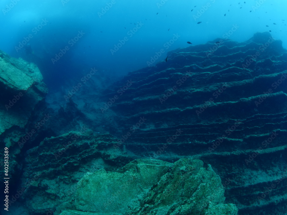 scuba diver underwater with rocks discovering reefs ocean scenery human