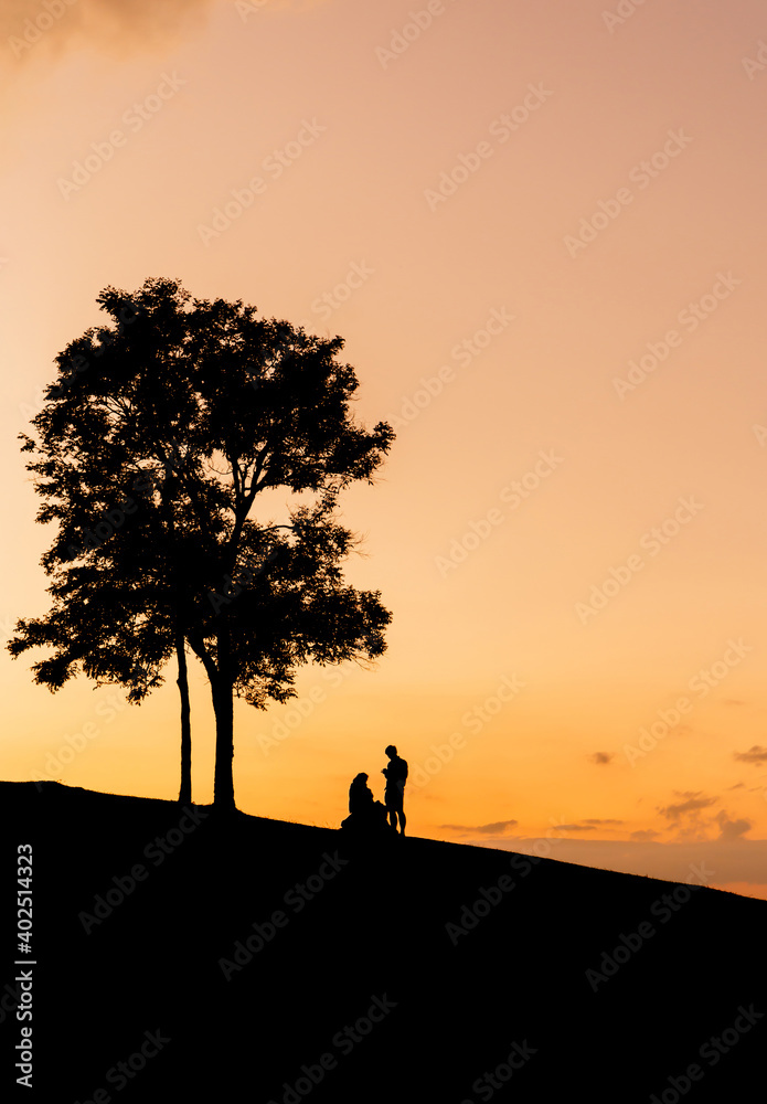 Silhouette of father mother and daughter playing at sunset in evening time, Happy family concept.