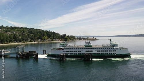 Cinematic drone tracking shot of the docking ferry at the ferry terminal with cars loading and unloading in Fountleroy, near Lincoln Park and Seattle, Washington photo