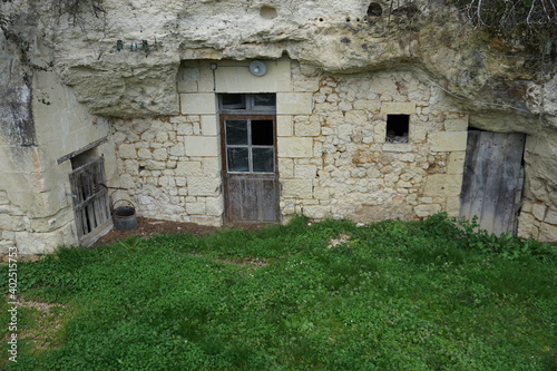 Fotografia old stone troglodyte with a broken wooden door in the Loire valley, France