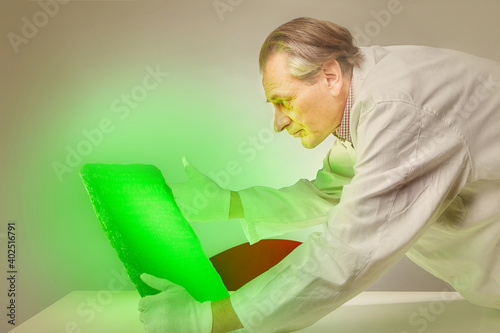 Museologist examining artifact of emerald tablet on his workplace photo