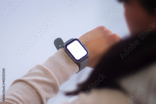 Female with a smartwatch and a white screen mockup on his hand. Man uses fitness tracker isolated on white background.