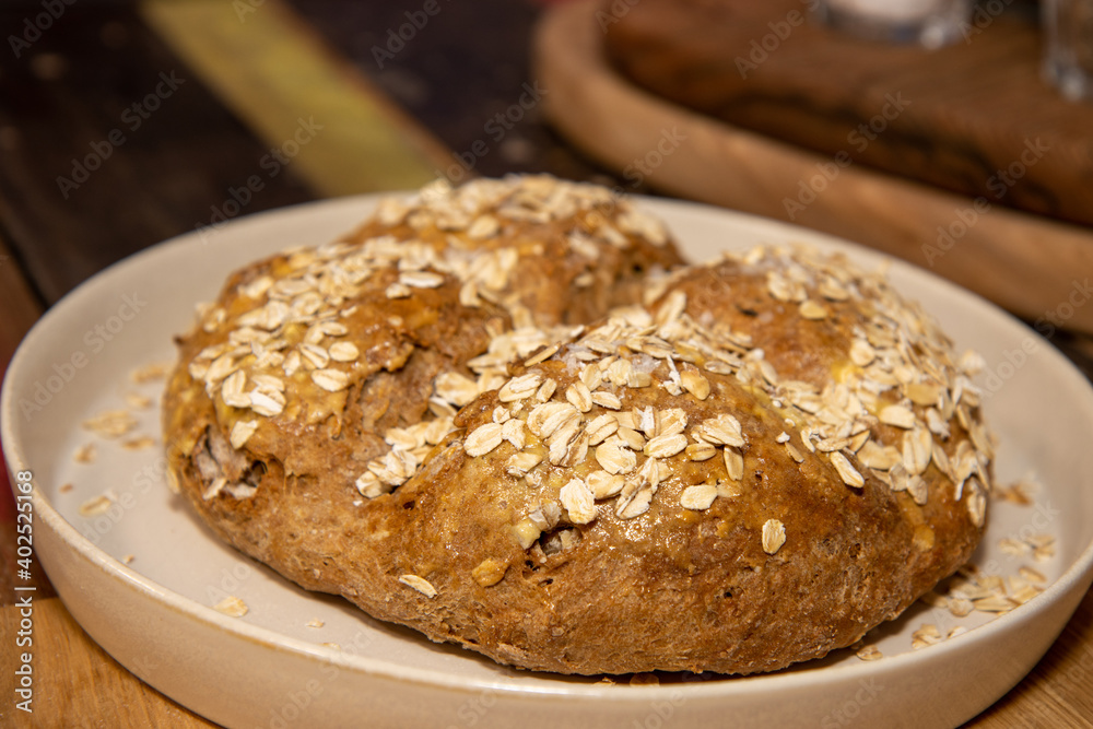 A round home baked bread roll covered in seeds