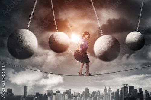 Businesswoman walking on a rope with obstacles photo