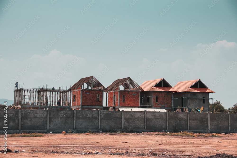 Rows of houses that are under construction on an arid and barren land Rows of houses that are under construction on an arid and barren land