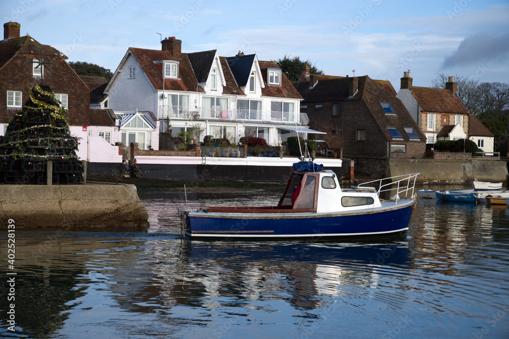 A local fishing boat leaving Emsworth Harbour with the Christmas Tree made of Lobster Pots in the background.