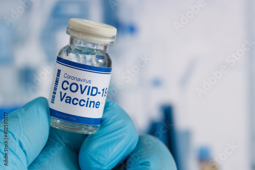 covid-19 vaccine in a medical research lab, a bottle of covid-19 vaccine, syringe for injection of vaccination, hand holding vaccine, covid-19 cure testing