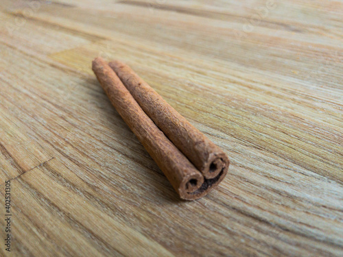 Single cinnamon stick on a wooden surface