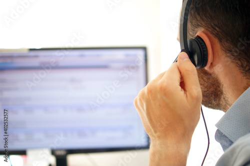 Call center man in blue shirt uniform working care customer service wearing headphone talking with customer at call center office. Support Customer Team 24 hours.
