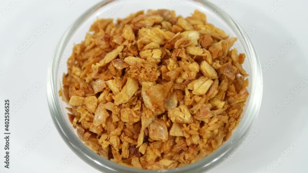 Close up chopped fried garlic in bowl on white background Close up chopped fried garlic in bowl on white background