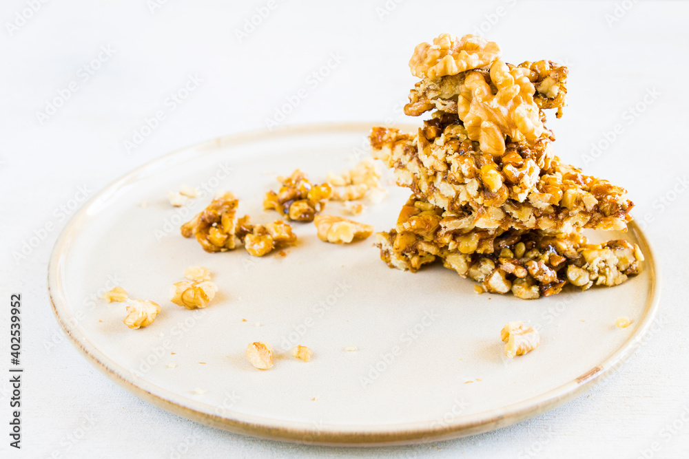 Georgia traditional dessert Gozinaki on the plate, nuts and honey Georgia traditional dessert Gozinaki on the plate, nuts and honey