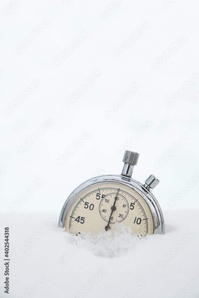 Fallen in the snow, in winter, stopwatch on a white background.