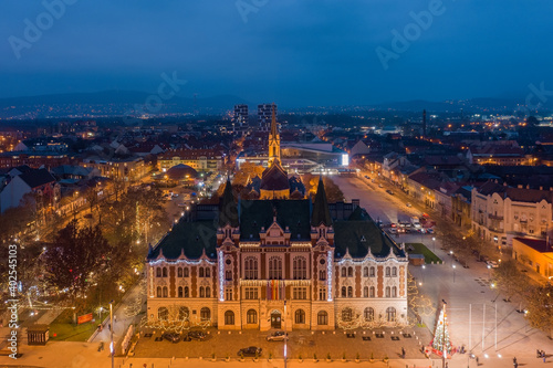 Újpest, Budapest, Hungary - Aerial view of city hall of Ujpest with Queen of Heaven church and Christmas lights. Blue hour cityscape. Újpest városháza. photo