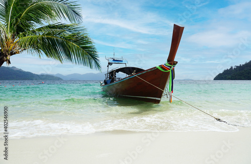 A boat that leads tourists to a white beach Near the coconut tree © Richman Photo