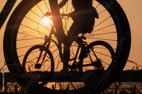 close-up silhouette of a bike wheel at sunset. The sun shines through the wheel of a bicycle, selective focus