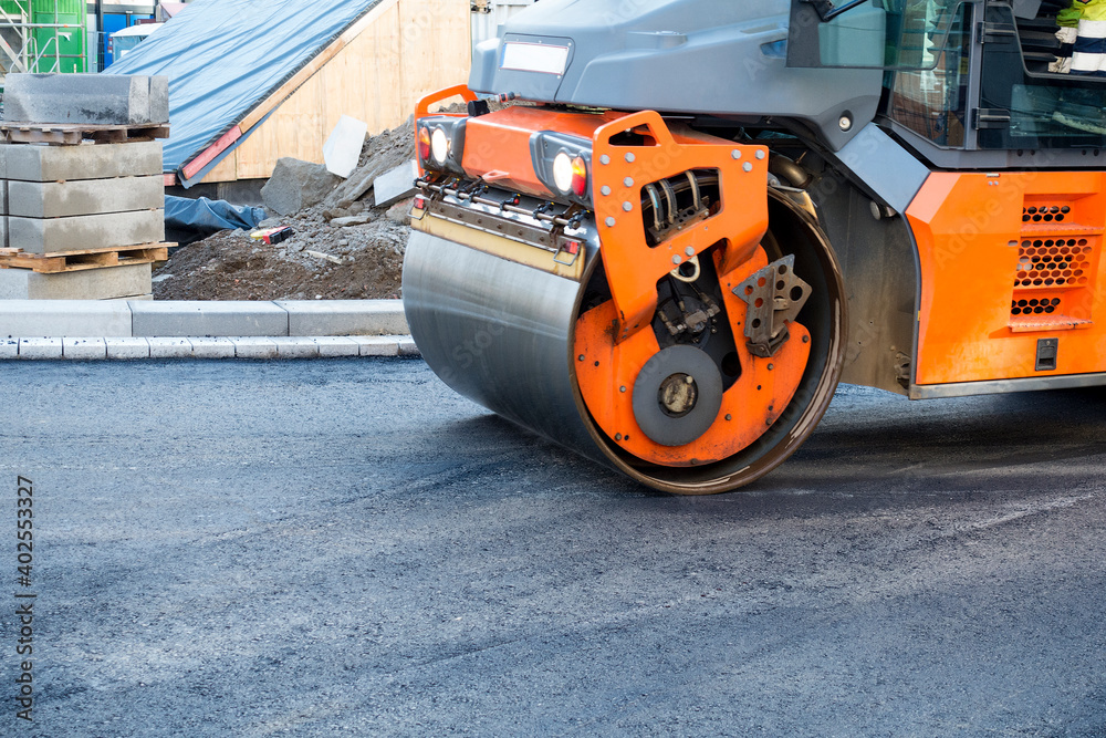 Modern heavy asphalt roller that stack and press hot asphalt. Yellow road repair machine. Repairing in modern city with vibration roller compactor Modern heavy asphalt roller that stack and press hot asphalt. Yellow road repair machine. Repairing in modern city with vibration roller compactor